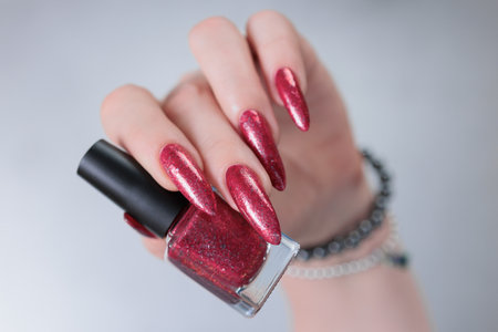 Female hands with long nails and red nail polishの写真素材