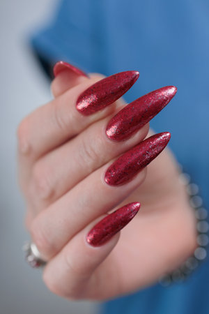Female hands with long nails and red nail polishの写真素材