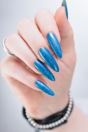 Woman's beautiful hand with long nails and bright blue manicureの写真素材