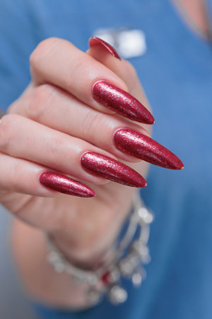 Female hands with long nails and red nail polishの写真素材
