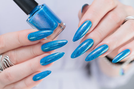 Woman's beautiful hand with long nails and bright blue manicureの写真素材