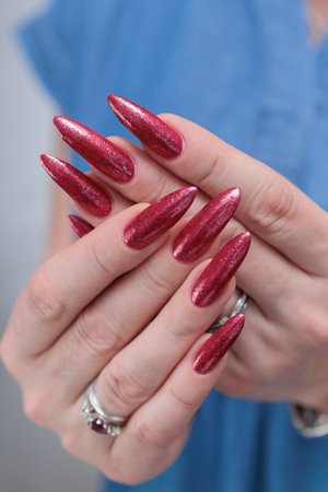Female hands with long nails and red nail polishの写真素材