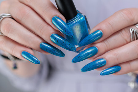 Woman's beautiful hand with long nails and bright blue manicureの写真素材