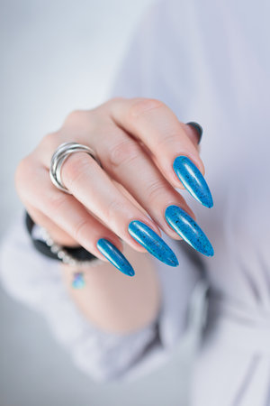 Woman's beautiful hand with long nails and bright blue manicureの写真素材