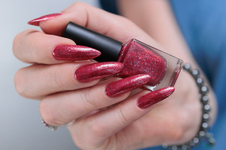 Female hands with long nails and red nail polishの写真素材