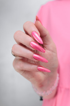 beautiful female hands with long nails and bright neon pink red nail polishの写真素材