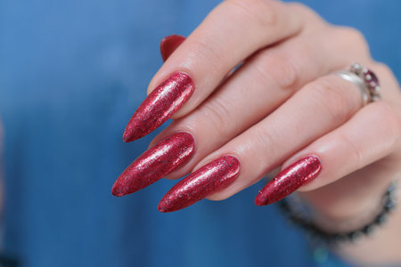 Female hands with long nails and red nail polishの写真素材