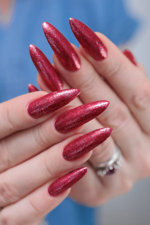 Female hands with long nails and red nail polishの写真素材