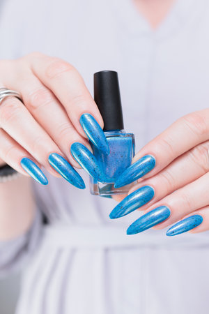 Woman's beautiful hand with long nails and bright blue manicureの写真素材