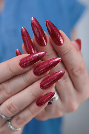 Female hands with long nails and red nail polishの写真素材