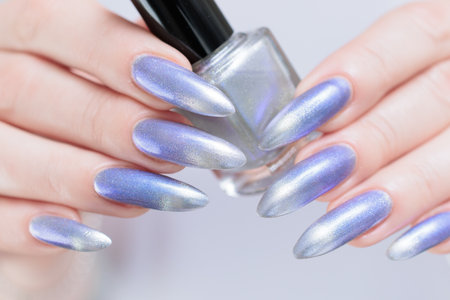 Female hand with long nails and bright light blue and silver manicureの写真素材