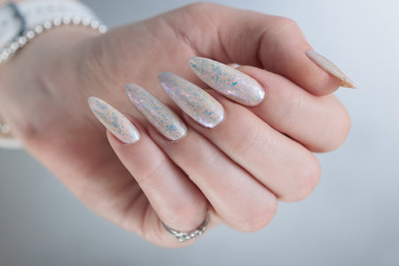 beautiful female hands with long nails light white manicureの写真素材