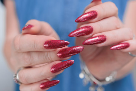 Female hand with long nails and a bright red manicureの写真素材