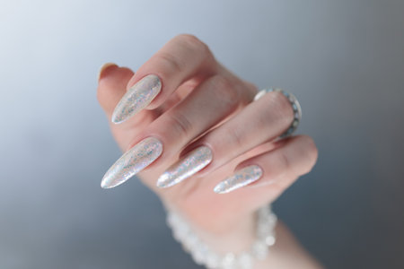 beautiful female hands with long nails light white manicureの写真素材