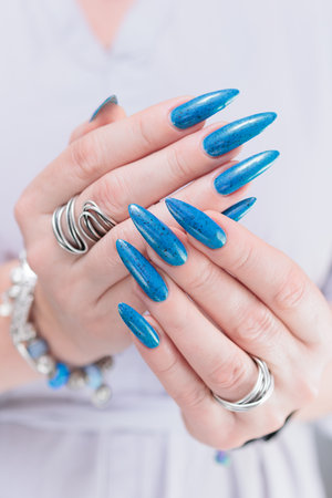Woman's beautiful hand with long nails and bright blue manicureの写真素材