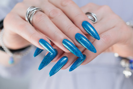 Woman's beautiful hand with long nails and bright blue manicureの写真素材