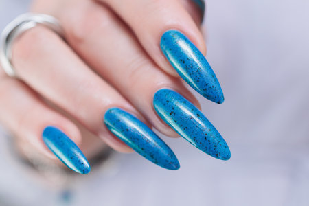 Woman's beautiful hand with long nails and bright blue manicureの写真素材