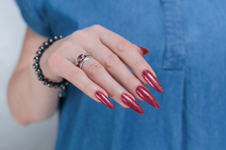 Female hand with long nails and a bright red manicureの写真素材
