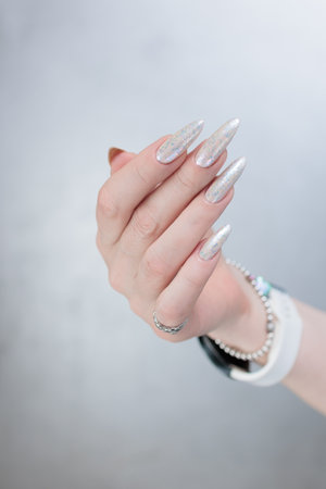 beautiful female hands with long nails light white manicureの写真素材