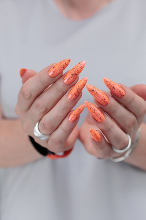 Hand with long nails and light orange neon manicureの写真素材