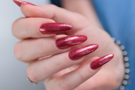 Female hand with long nails and a bright red manicureの写真素材