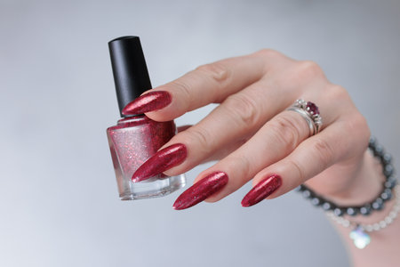 Female hand with long nails and a bright red manicureの写真素材