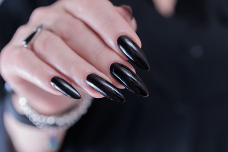 Female hands with long nails and black manicure