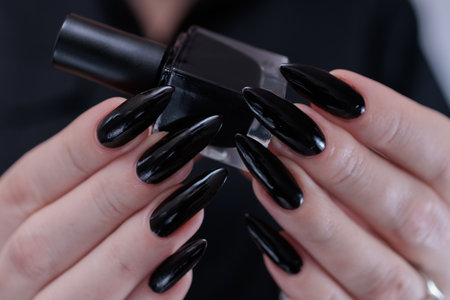 Female hands with long nails and black manicureの写真素材