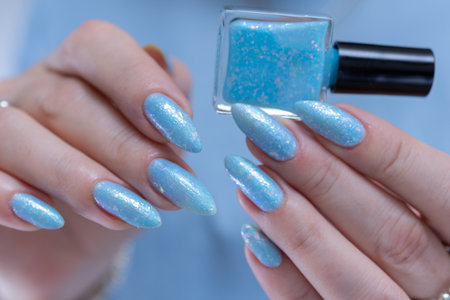 Woman's beautiful hand with long nails and light baby blue manicureの写真素材