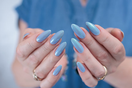 Woman's beautiful hand with long nails and light baby blue manicureの写真素材