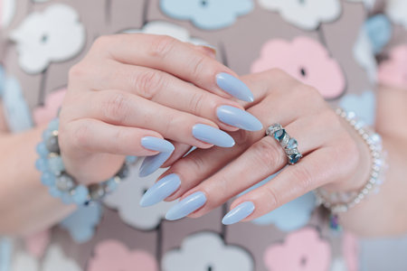Woman's beautiful hand with long nails and light baby blue manicureの写真素材