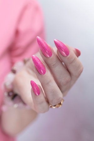 beautiful female hands with long nails and bright neon pink red nail polishの写真素材