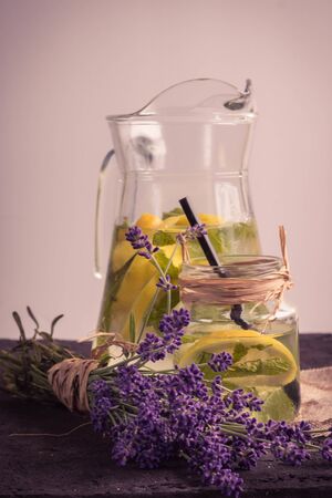 Jug and glass of fresh lemonade on blue wooden backgroundの写真素材
