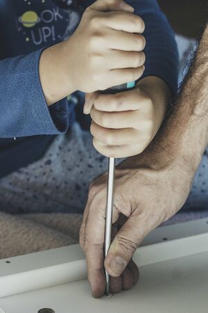 Hands of father and child working with toolsの写真素材
