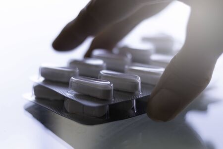 Pills in capsules on glass counter and white backgroundの写真素材