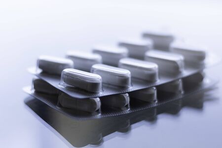 Pills in capsules on glass counter and white backgroundの写真素材