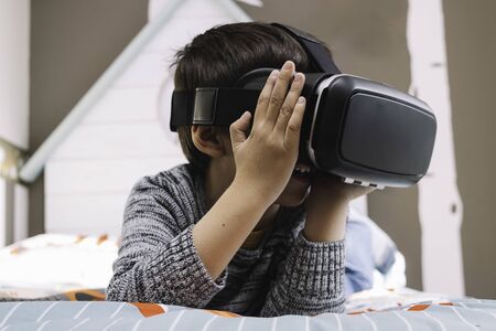 Boy with virtual reality glasses in his roomの写真素材
