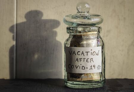Glass jar saves savings for vacation after Covid-19 Money saved in a boat for when the pandemic passesの写真素材