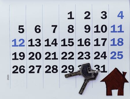 Calendar in the foreground with cardboard house and keys Conceptual of savings, monthly spending economy, rent, mortgageの写真素材
