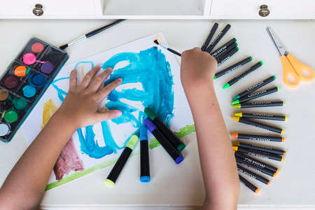 Child hands painting and doing crafts at home Conceptual new normal after the pandemic, doing homework at homeの写真素材