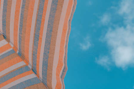 Beach umbrella viewed from below silhouetted against blue sky Conceptual of vacation, tourism, relaxの写真素材