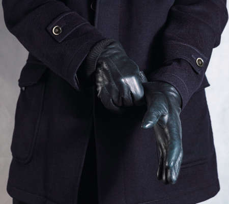 Male hands putting on black fur glovesの写真素材