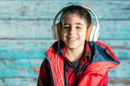 Boy listens to music with headphones and latest generation mobile technologyの写真素材