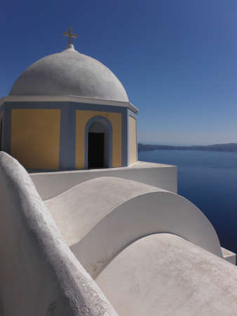 Santorini from above with a white facade in the foreground and the sea and deep blue sky in the backgroundの写真素材