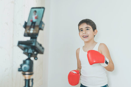 Boy practices boxing while recording with a mobile phoneの写真素材