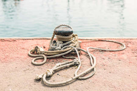 Pier, mooring bollard of a boat with ropeの写真素材
