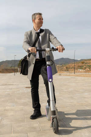 Elegant businessman with electric scooter in the cityの写真素材