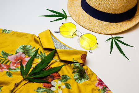 Yellow sunglasses, hat, marijuana leaves, yellow shirt - assembled in the form of a portrait of a man. Nothing style, indie, rastaman, hippie, hipster. Rastaman holiday. Selective focus.の写真素材