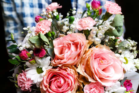 Extremely close-up. Man gives flowers. Gift box with flowers. Close up of box with pink roses in male hands. Male give gift for mothers day, valentines, women day, birthday. Selective focusの写真素材