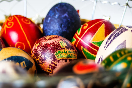DEFOCUS Easter eggs. Close-up round basket with colorful easter eggs on white background. Red, blue,...